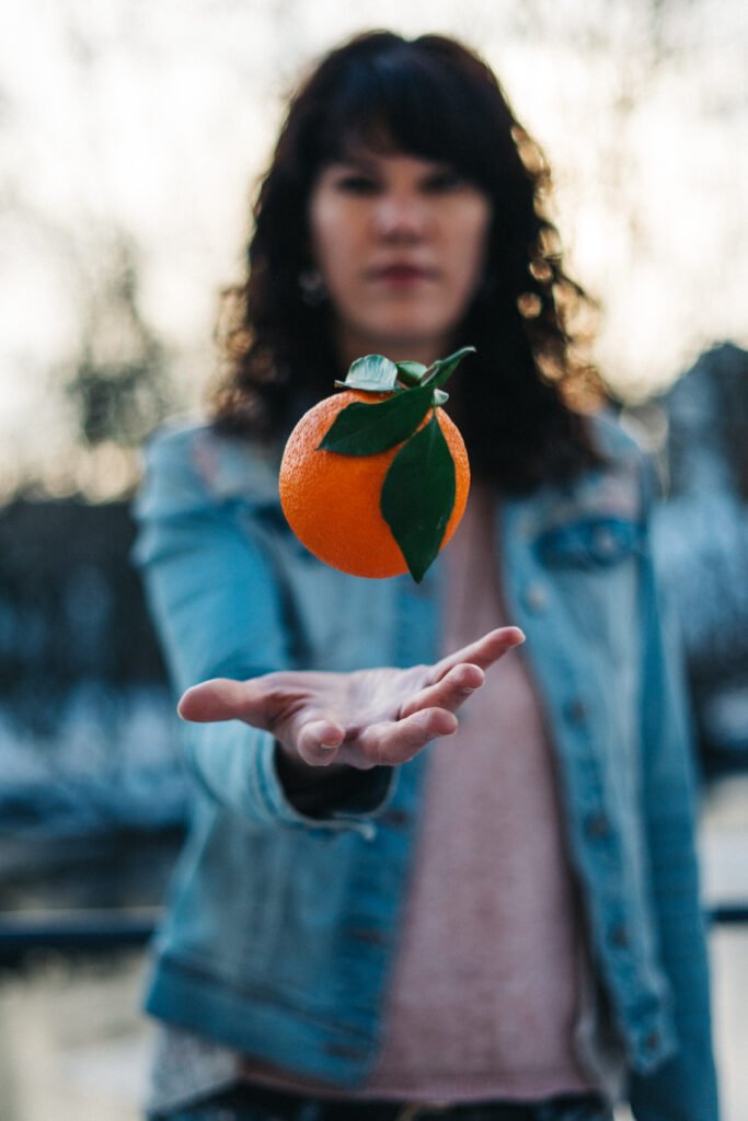 Frau wirft Orange in die Luft